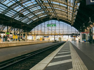 Köln, Almanya - 19 Mart 2022 - Üzerinde büyük bir kubbe ve Detex yazan bir tabela olan bir tren istasyonu. İstasyon boş ve gökyüzü temiz.