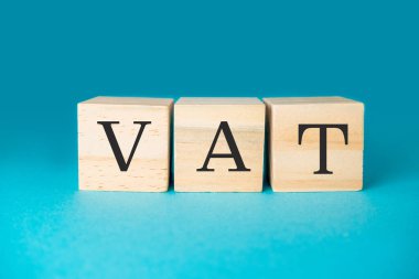 Wooden blocks forming the word VAT value added tax over a blue gradient background, ideal for tax related concepts clipart