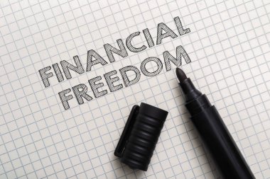 İşaretleyici, üzerinde siyahla yazılmış finansal özgürlük yazan bir kağıt parçasında. Ekonomik bağımsızlık kavramı ve finansal açıdan güvende olmanın önemi