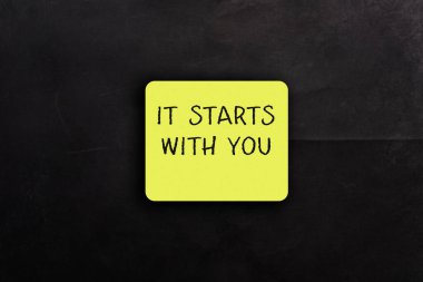 Üzerinde senin yazmanla başlayan sarı etiket. Çıkartma siyah arkaplana yerleştirildi