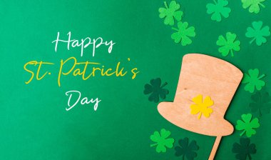 Green background with a hat and shamrock on it. The hat is on top of the shamrock, creating a festive and celebratory atmosphere clipart