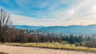 Uzakta küçük bir kasabası olan güzel bir dağ manzarası. Gökyüzü açık ve mavidir birkaç bulutla