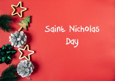 Kırmızı arka planda bir Noel ağacı ve yıldızlar. Aziz Nicholas Günü 'nün sözleri beyazla yazılmıştır.