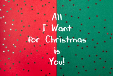 Yıldız desenli yeşil ve kırmızı arkaplan ve Noel için tek istediğim senin beyaz yazman.