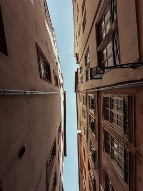 İkisi arasında açık mavi gökyüzü olan iki bina. Gökyüzü, iki binanın ortasında görünen tek şey.
