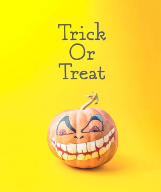 Yüzü boyalı bir balkabağı ve altında 