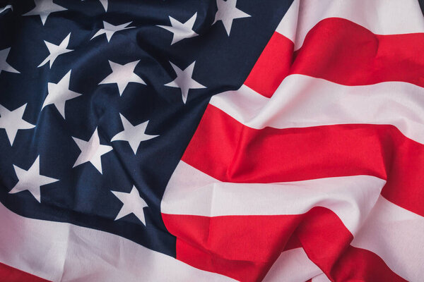 Красный, белый и синий американский флаг со звездами. Звезды разных размеров и разбросаны поперек флага