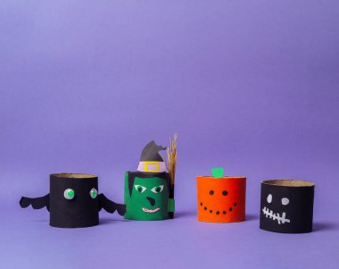 Kâğıt tüplerden yapılmış bir grup Cadılar Bayramı süsü. Tüplerden birinde balkabağı var.