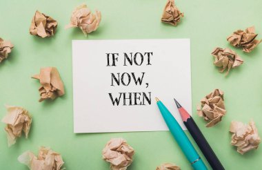 Üzerinde şu an değilse bile, üzerinde yazı olan bir kağıt parçası. Ayrıca kağıtta iki kalem var.