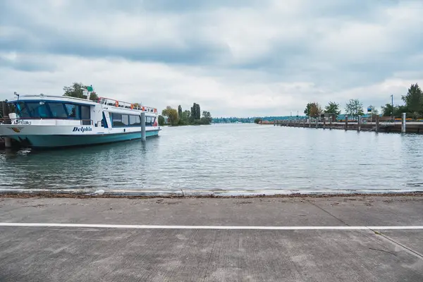 Basel, İsviçre - 13 Mayıs 2023 - Tekne rıhtıma yanaştı. Su sakin ve gökyüzü bulutlu. Tekne beyaz ve mavi.