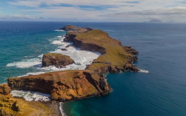 Madeira 'daki Sao Lourenco yarımadası hava aracı görüntüsünden. Ponta de So Loureno. Mavi okyanus dalgalı volkanik kayalar ve drone manzaralı bulutlar..