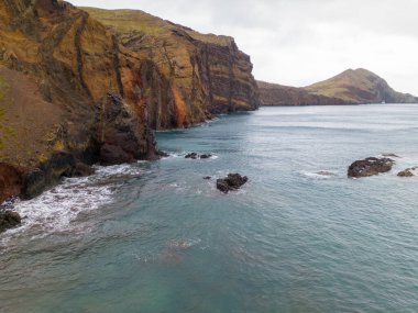 Madeira 'daki Sao Lourenco yarımadası hava aracı görüntüsünden. Ponta de So Loureno. Mavi okyanus dalgalı volkanik kayalar ve drone manzaralı bulutlar..