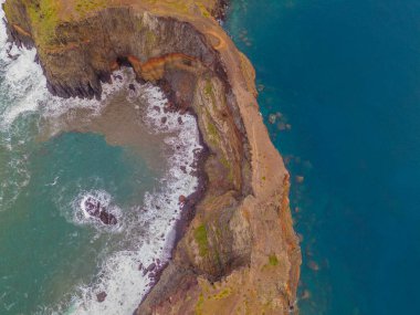 Madeira 'daki Sao Lourenco yarımadası hava aracı görüntüsünden. Ponta de So Loureno. Mavi okyanus dalgalı volkanik kayalar ve drone manzaralı bulutlar..