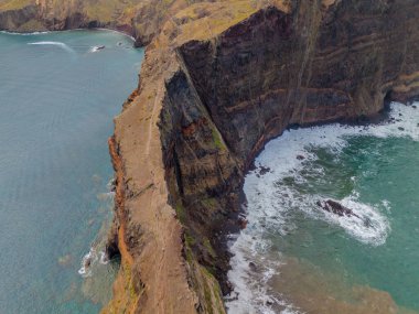 Madeira 'daki Sao Lourenco yarımadası hava aracı görüntüsünden. Ponta de So Loureno. Mavi okyanus dalgalı volkanik kayalar ve drone manzaralı bulutlar..
