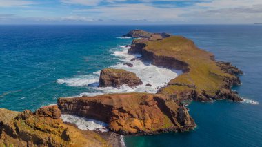 Madeira 'daki Sao Lourenco yarımadası hava aracı görüntüsünden. Ponta de So Loureno. Mavi okyanus dalgalı volkanik kayalar ve drone manzaralı bulutlar..
