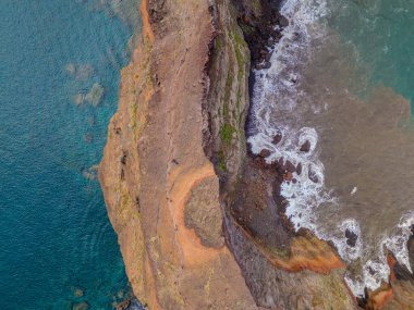 Madeira 'daki Sao Lourenco yarımadası hava aracı görüntüsünden. Ponta de So Loureno. Mavi okyanus dalgalı volkanik kayalar ve drone manzaralı bulutlar..