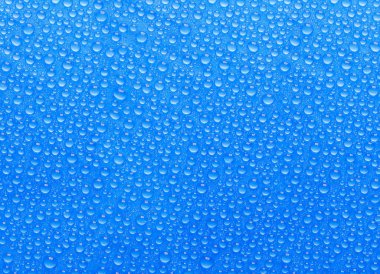 Mavi bir yüzeyde bir sürü küçük mavi su damlası.