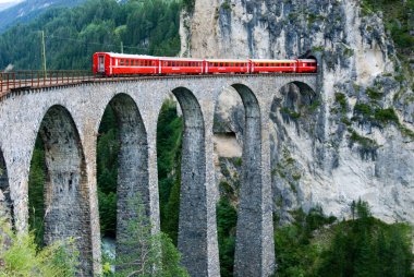 red train of Glacier Express on Viaduct Landwasserviadukt, Filisur, Grisons, Switzerland clipart