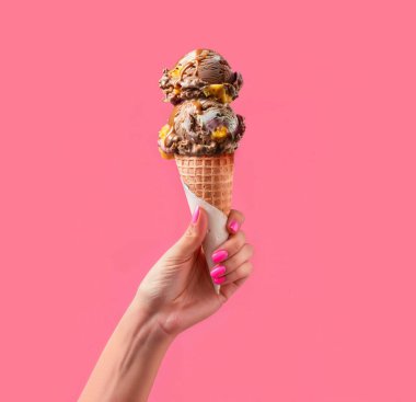 Pembe arka plan şablonunda bir kadın tarafından tutulan lezzetli çikolatalı dondurma.