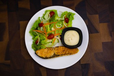 Masadaki somon salatası, yemek ve yemek sahnelerinde reklam ve duvar kağıtları için arka plan. Dekorasyon fikirlerinde gerçek görüntüler.