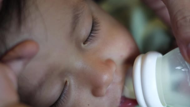 婴儿从奶瓶里挤奶 睡着了 靠近点用奶瓶喂养婴儿 — 图库视频影像