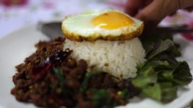 Tayland usulü Kızarmış Kıymalı Biftek ve Pirinçli Kutsal Fesleğen. Fesleğenli kızarmış biftek pilav, fast food ve Asya ve Tayland 'da meşhurdur..