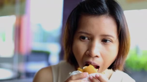一个吃汉堡包的女人模糊的背景 — 图库视频影像