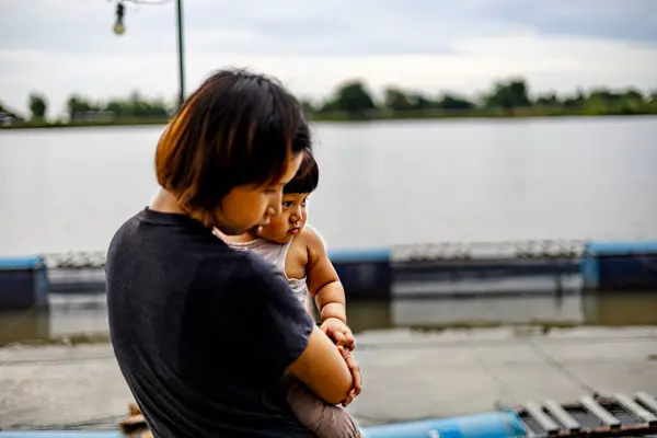 Mother and son watching fish in a pond of a fish farm. Fisherman Family.