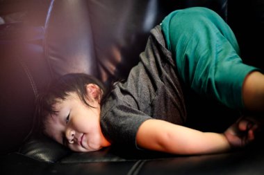 Cute boy lying face down on the sofa with butt up in the air.