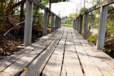 Şehir parkındaki bir nehirden geçen tahta köprü. Terk Edilmiş Tahta Kaldırımlar Uzaklara Gidiyor.