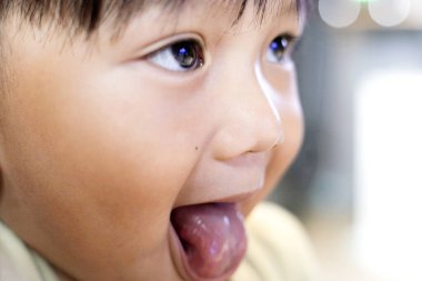 küçük oğlan dilini yapışkanlık dışarı. 