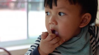 Anne, yeni yürümeye başlayan bebeğini tutuyor, sosis yiyor, belgesel çekimleri için ve yemek ve içki sahnesinde yaşam tarzı için..