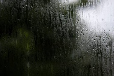 Pencerenin dışındaki cama yağmur damlaları.