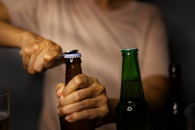 Kadınların eli kapağı açar. Taze bira. Bira şişe açacağının yardımıyla açılır..