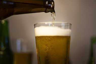 Bira şişeden bira bardağına dökülür. Taze bira bardağa döküldü..