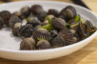 Kaynamış midyeler seramik tabakta, eski ahşap dokuda..