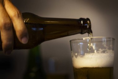 Bira şişeden bira bardağına dökülür. Taze bira bardağa döküldü..