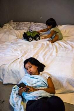 Annem yerde yatıyordu çünkü çocuğa bakmaktan yorulmuştu. Reklam ve duvar kâğıdı için rahatlama ve yaşam tarzı sahnesinde arka plandaydı..