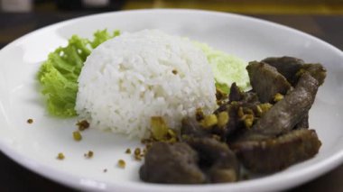 Beyaz Tabakta Pirinçli Kızarmış Domuz eti, yemek sahnesinde belgesel ve sinema için video görüntüleri.