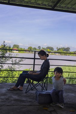 Yürüyen Çocuk, telefonda oynayan annesini bekliyor. Eğitim ve yaşam tarzında reklam ve duvar kâğıdı için arka plan..