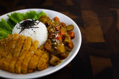 Tabağa yerleştirilmiş körili tavuk, ahşap masa, kültür ve yemek sahnesinde reklam ve duvar kağıdı için arka plan..