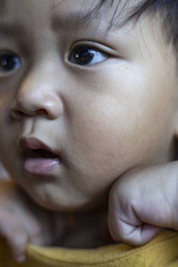 Güneydoğu Asyalı Bebek Yüzü 'nün Kapanışı, gülümseyen Güneydoğu Asyalı bir çocuğun tatlı yakın çekimi, aile reklamları için mükemmel..