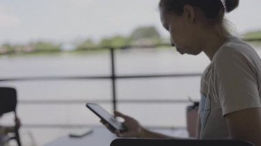 Annesi, çocuğu oyun oynarken telefonuna odaklanmış durumda, dikkati dağılmış bir anne, bebeğinin, modern bir aile draması sahnesi için mükemmel olan bloklarla oynarken, telefonunu dikkatle kaydırıyor..