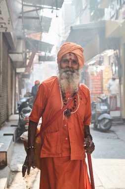 Amritsar, Punjab, Hindistan - Geleneksel turuncu elbiseli Sadhu sabahın erken saatlerinde yolda yürüyor