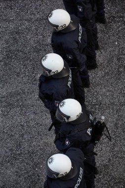 İsyan teçhizatlı bir grup polis yukarıdaki sokakta dikiliyor.