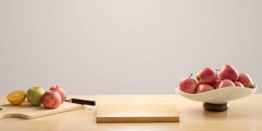 Bir kase meyve, kesme tahtasının yanındaki masada oturuyor.