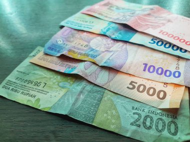 Endonezya rupia banknotlarını ahşap arka planda izole edilmiş yüz, elli, on, beş bin ve iki bin banknotla kapatın. Para yönetimi kavramı.