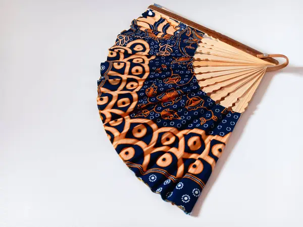 Endonezya geleneksel el vantilatörü veya beyaz arka planda izole edilmiş bambu saplı ve batik desenli yelpaze..