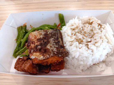 Süt balıklı beyaz pirinç, tempe orek veya kızarmış tempeh, karton beslenme çantasında yeşil fasulye..