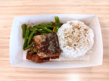 White Rice with presto milkfish, tempe orek or stir fried tempeh, green beans in a paper box. Flat lay.